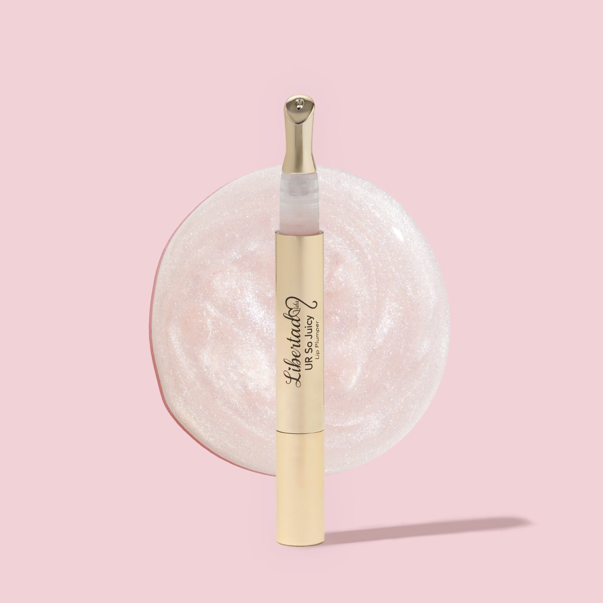 Lip gloss with a swatch on a pink background