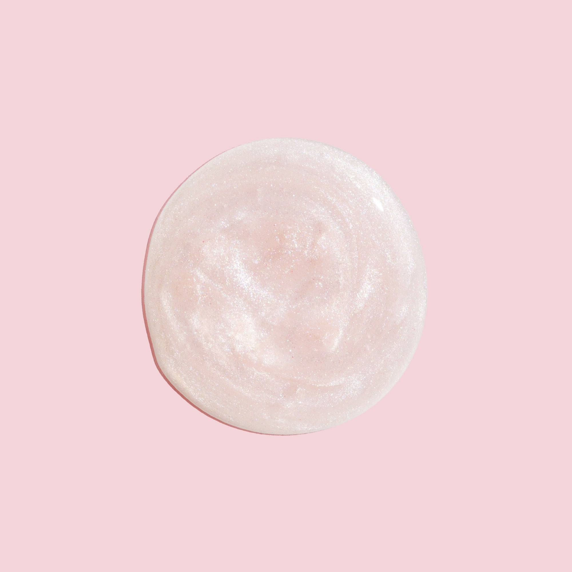 Round, white, textured swatch on a pink background
